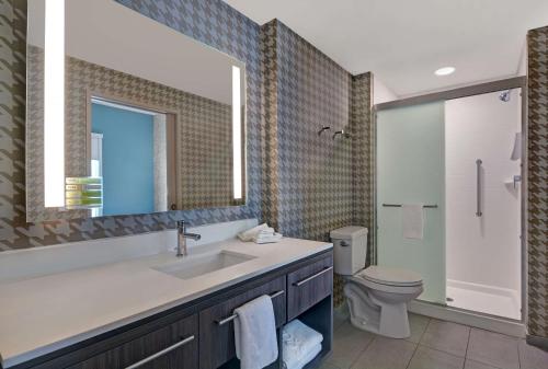 a bathroom with a sink and a toilet and a mirror at Home2 Suites By Hilton Richmond Hill Savannah I-95 in Richmond Hill