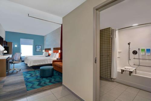 a hotel room with a bed and a bathroom at Home2 Suites By Hilton Richmond Hill Savannah I-95 in Richmond Hill