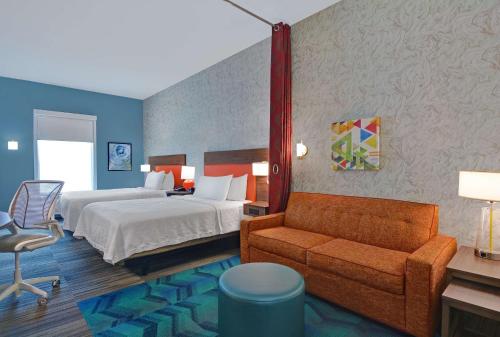 リッチモンドヒルにあるHome2 Suites By Hilton Richmond Hill Savannah I-95のベッドとソファ付きのホテルルーム