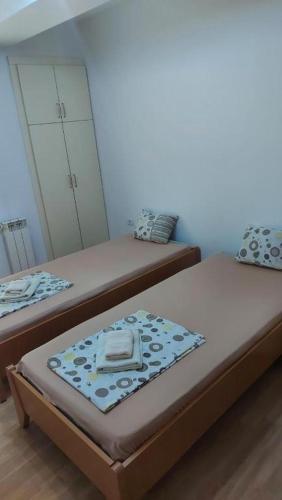 two twin beds in a room with a mirror at Exclusive Skopje Apartments in Skopje