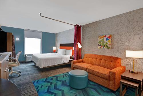 a hotel room with a bed and a couch at Home2 Suites By Hilton Richmond Hill Savannah I-95 in Richmond Hill