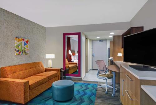 a living room with a couch and a television in a room at Home2 Suites By Hilton Richmond Hill Savannah I-95 in Richmond Hill