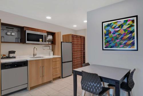 a kitchen with a table and a dining room at Home2 Suites By Hilton Richmond Hill Savannah I-95 in Richmond Hill