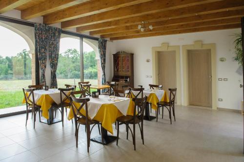 ein Esszimmer mit Tischen und Stühlen sowie gelben Servietten in der Unterkunft Paradiso degli Ulivi B&B in Peschiera del Garda