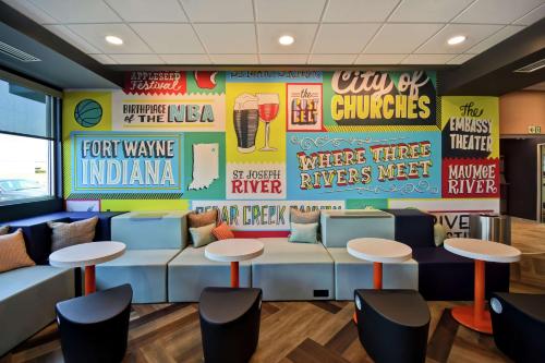 a waiting room at a fast food restaurant with tables and stools at Tru By Hilton Fort Wayne in Fort Wayne