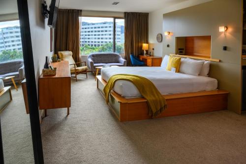 a hotel room with a large bed and a living room at Ohtel Wellington in Wellington