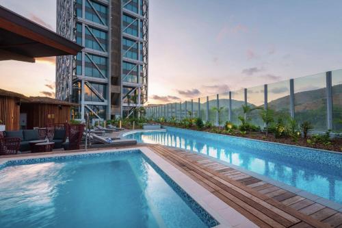 - une piscine avec vue sur un bâtiment dans l'établissement Hilton Port Moresby Hotel & Residences, à Port Moresby