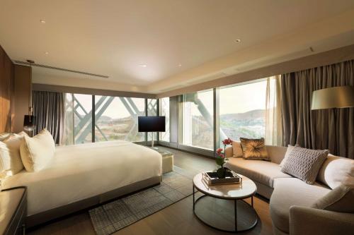 Habitación de hotel con cama grande y sofá en Hilton Port Moresby Hotel & Residences, en Port Moresby