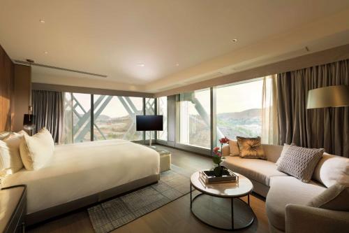 莫尔兹比港Hilton Port Moresby Hotel & Residences的配有一张大床和一张沙发的酒店房间
