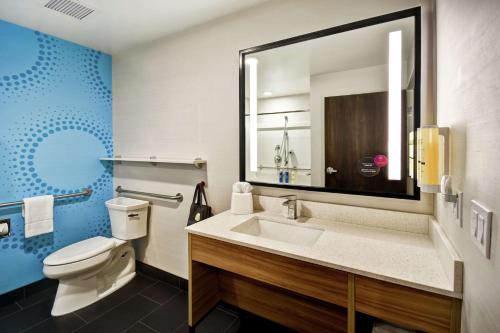 ein Badezimmer mit einem WC, einem Waschbecken und einem Spiegel in der Unterkunft Tru By Hilton Fort Wayne in Fort Wayne
