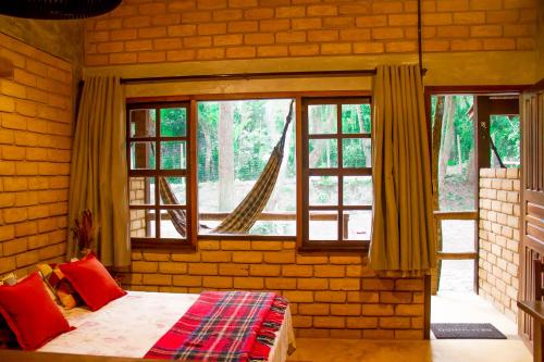 ein Schlafzimmer mit einem Bett in einer Ziegelwand in der Unterkunft Chalé 03 Itaipu Vale da Colina Niterói in Niterói