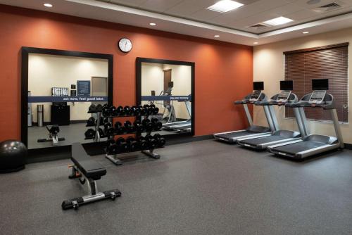 a gym with several tread machines and mirrors at Hampton Inn & Suites Buena Park in Buena Park