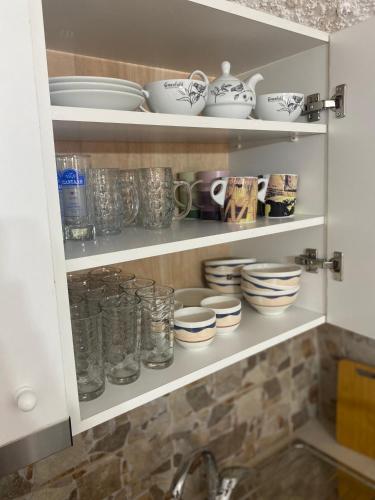a kitchen cupboard with dishes and bowls on it at Terra Petra Mani in Koíta