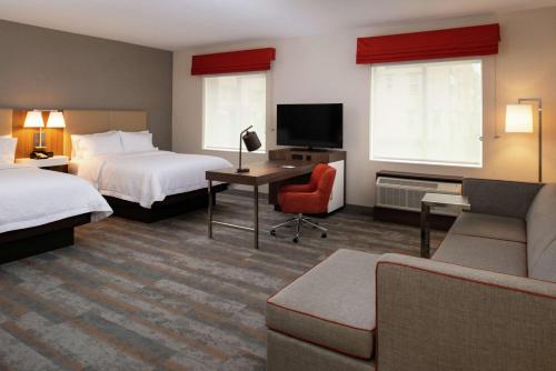 a hotel room with two beds and a television at Hampton Inn & Suites Buena Park in Buena Park