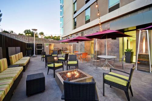 a patio with chairs and tables and a fire pit at Home2 Suites by Hilton Los Angeles Montebello in Montebello