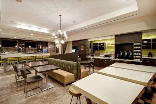 a restaurant with tables and chairs and a bar at Home2 Suites by Hilton Los Angeles Montebello in Montebello