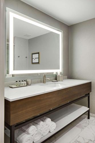 a bathroom with a sink with a large mirror at The Sire Hotel Lexington, Tapestry Collection by Hilton in Lexington