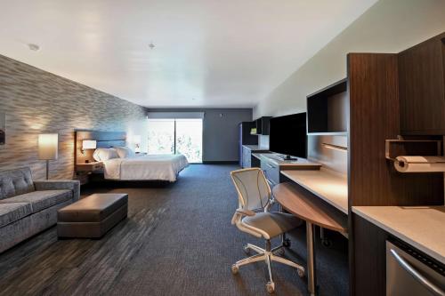 a large hotel room with a bed and a desk at Home2 Suites by Hilton Los Angeles Montebello in Montebello