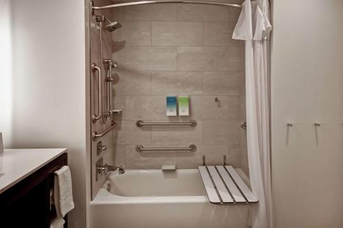 a bathroom with a shower with a white tub at Home2 Suites by Hilton Los Angeles Montebello in Montebello