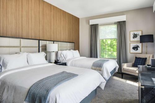 una habitación de hotel con 2 camas y una silla en The Sire Hotel Lexington, Tapestry Collection by Hilton en Lexington