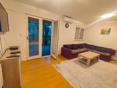 uma sala de estar com um sofá e uma mesa em Jablanica villa with pool em Jablanica