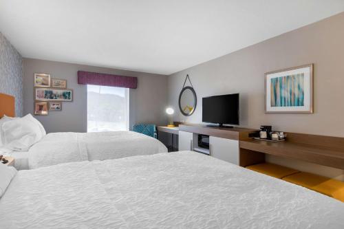 a hotel room with two beds and a desk with a television at Hampton Inn & Suites Ruidoso Downs in Ruidoso Downs
