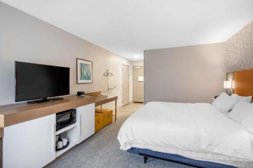 a hotel room with a bed and a flat screen tv at Hampton Inn & Suites Ruidoso Downs in Ruidoso Downs