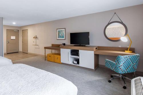 a bedroom with a bed and a desk with a television at Hampton Inn & Suites Ruidoso Downs in Ruidoso Downs