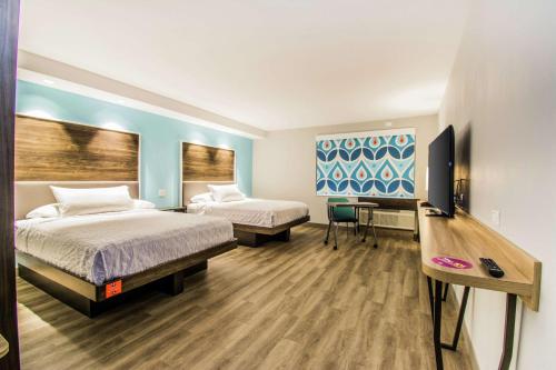 um quarto de hotel com duas camas e uma secretária em Tru By Hilton Bowling Green em Bowling Green