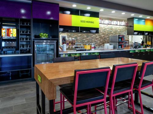 a restaurant with a wooden table and four pink chairs at Home2 Suites By Hilton Oklahoma City Nw Expressway in Oklahoma City