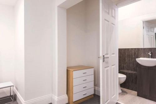 La salle de bains blanche est pourvue d'un lavabo et de toilettes. dans l'établissement Perfect for Professionals & Business Travellers - Leeds City Views - Monthly Offers!, à Leeds