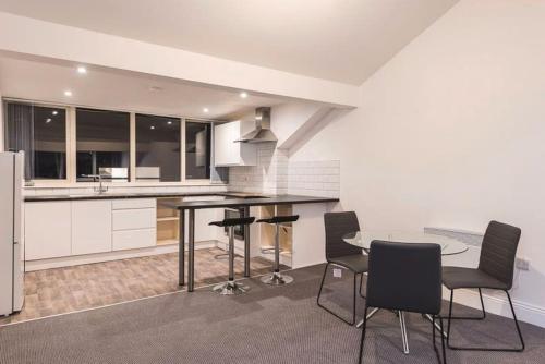 a kitchen with a table and chairs in a room at Perfect for Professionals & Business Travellers - Leeds City Views - Monthly Offers! in Leeds