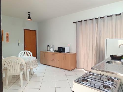a kitchen with a sink and a table and a stove at Lindo Apto103 em Primavera do Leste in Primavera do Leste