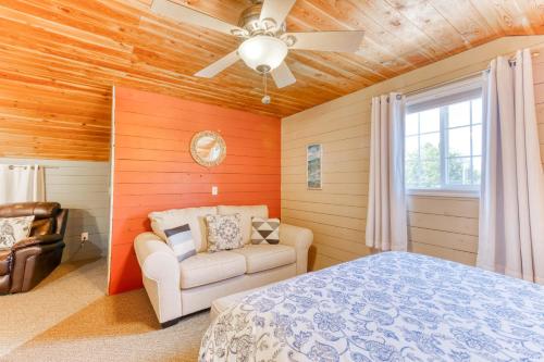 a bedroom with a bed and a chair and a ceiling fan at Sand Dollar Cottage Rockaway - Meredith Lodging in Rockaway Beach