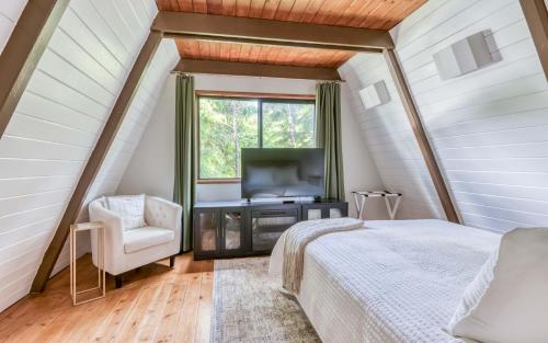 Schlafzimmer mit einem Bett, einem TV und einem Fenster in der Unterkunft Onyx Point in Forfar