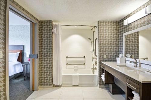 a bathroom with a tub and a shower and a sink at Home2 Suites By Hilton Portland Airport in South Portland