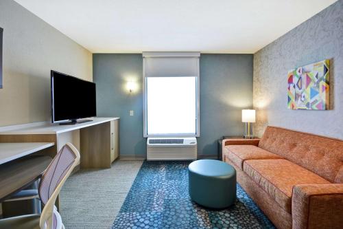 a living room with a couch and a tv at Home2 Suites By Hilton Portland Airport in South Portland