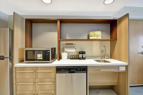 a kitchen with a sink and a microwave at Home2 Suites By Hilton Portland Airport in South Portland