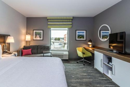 阿倫派克的住宿－Hampton Inn & Suites - Allen Park，配有一张床和一张书桌的酒店客房