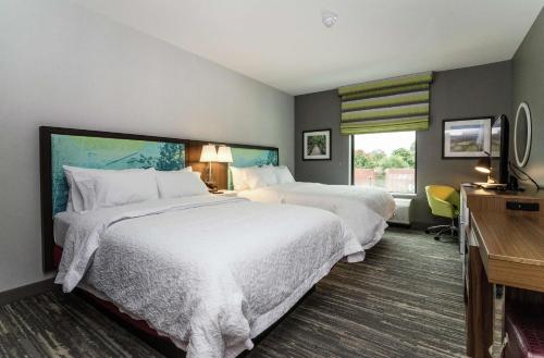a hotel room with two beds and a desk at Hampton Inn & Suites - Allen Park in Allen Park