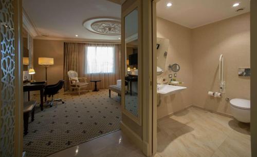 a bathroom with a sink and a toilet and a desk at DoubleTree By Hilton Gaziantep in Gaziantep