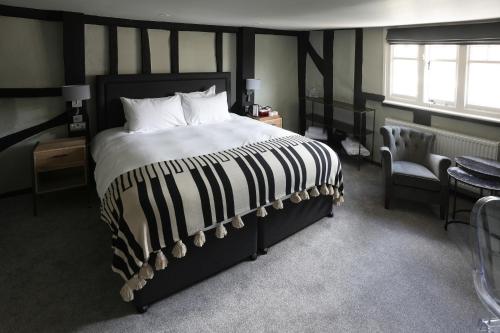 a bedroom with a large bed and a chair at The Windmill in Maidstone