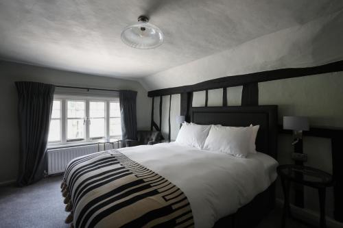 ein Schlafzimmer mit einem großen Bett und einem Fenster in der Unterkunft The Windmill in Maidstone
