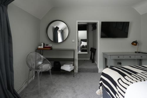 a bedroom with a bed and a mirror and a chair at The Windmill in Maidstone