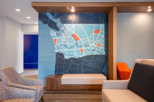a wall mural in a waiting room with two chairs at Holiday Inn Express Bothell by IHG in Bothell