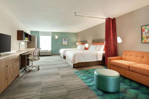 Habitación de hotel con cama y sofá en Home2 Suites By Hilton Sarasota Bradenton Airport, en Sarasota