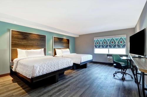 a hotel room with two beds and a desk at Tru By Hilton Edmonton Windermere in Edmonton