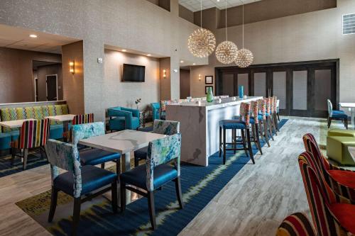 プラノにあるHampton Inn & Suites Dallas/Plano Centralのテーブルと椅子のあるレストラン、バー