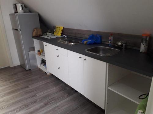 encimera con fregadero y nevera en 2 Zimmer Apartment, en Hannover