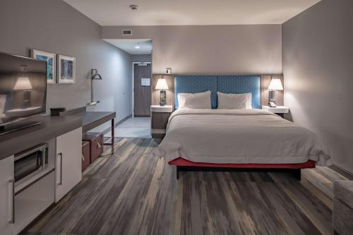 a bedroom with a bed and a flat screen tv at Hampton Inn & Suites Dallas/Plano Central in Plano